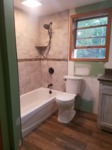 remodeled rustic tub shower and toilet